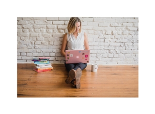 Woman writing a book on a laptop.